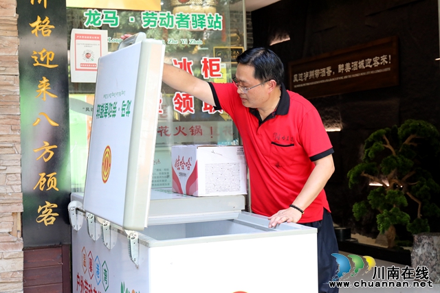 餐館老板李青為愛心冰柜加礦泉水-謝汶萍攝.JPG